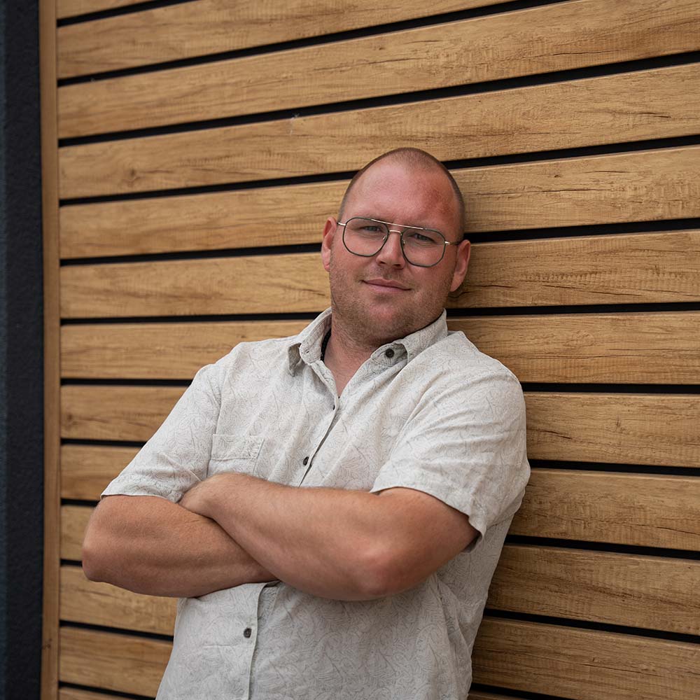 Maximilian Jäger, Geschäftsführer FairGarden, vor einer Fassade aus Rhombuspaneelen