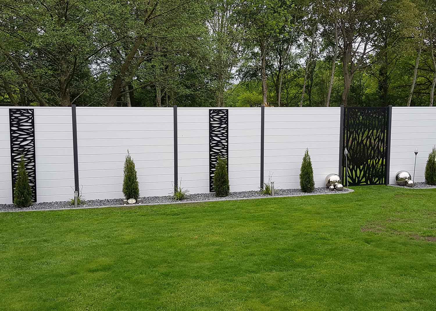 Sichtschutz im Garten aus Kunststoff in Weiß mit verschiedenen Metall-Elementen davor