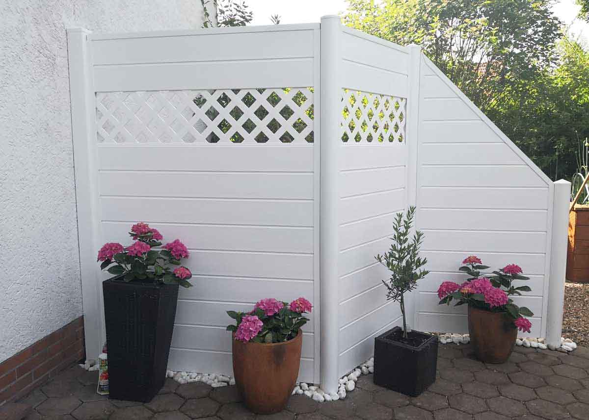 weißer PVC Sichtschutz mit Rankgitter und Rundpfosten mit schrägem Eckelement an der Terrasse