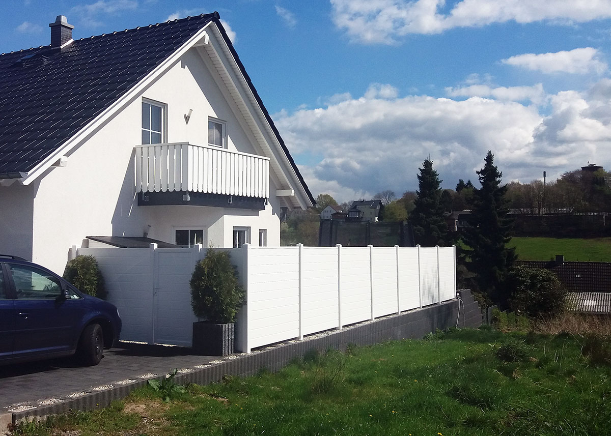 Sichtschutzwand in Weiß um einen Gartengrundstück mit passender Sichtschutztür