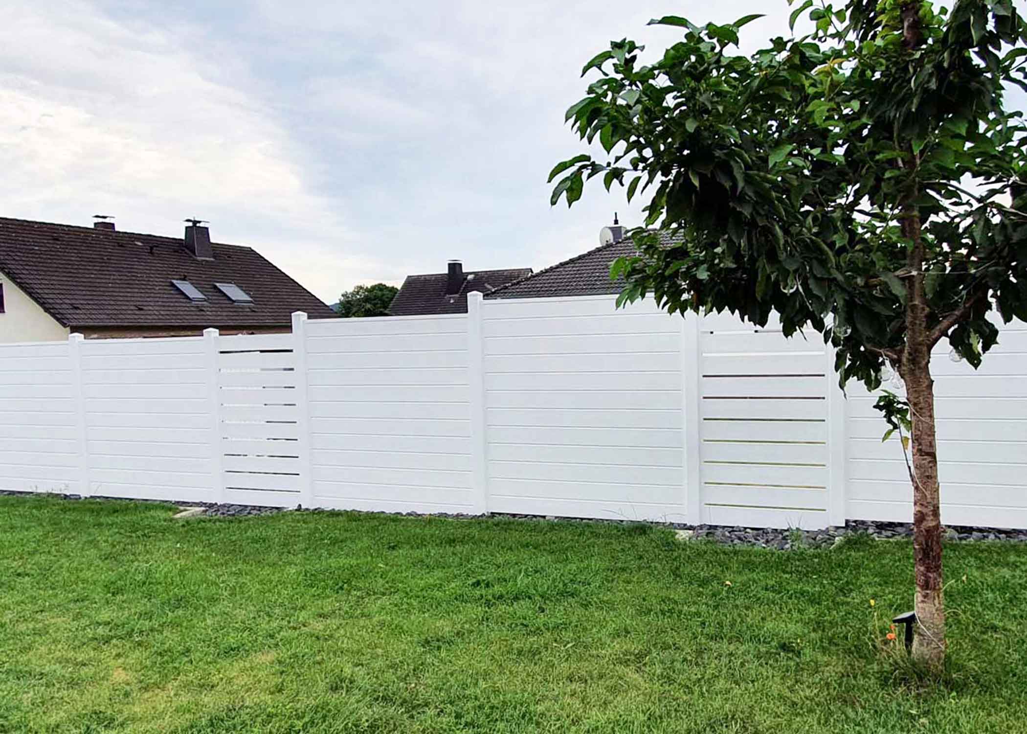langer Sichtschutzzaun im Garten mit Auflockerung durch Spaltelemente in Weiß