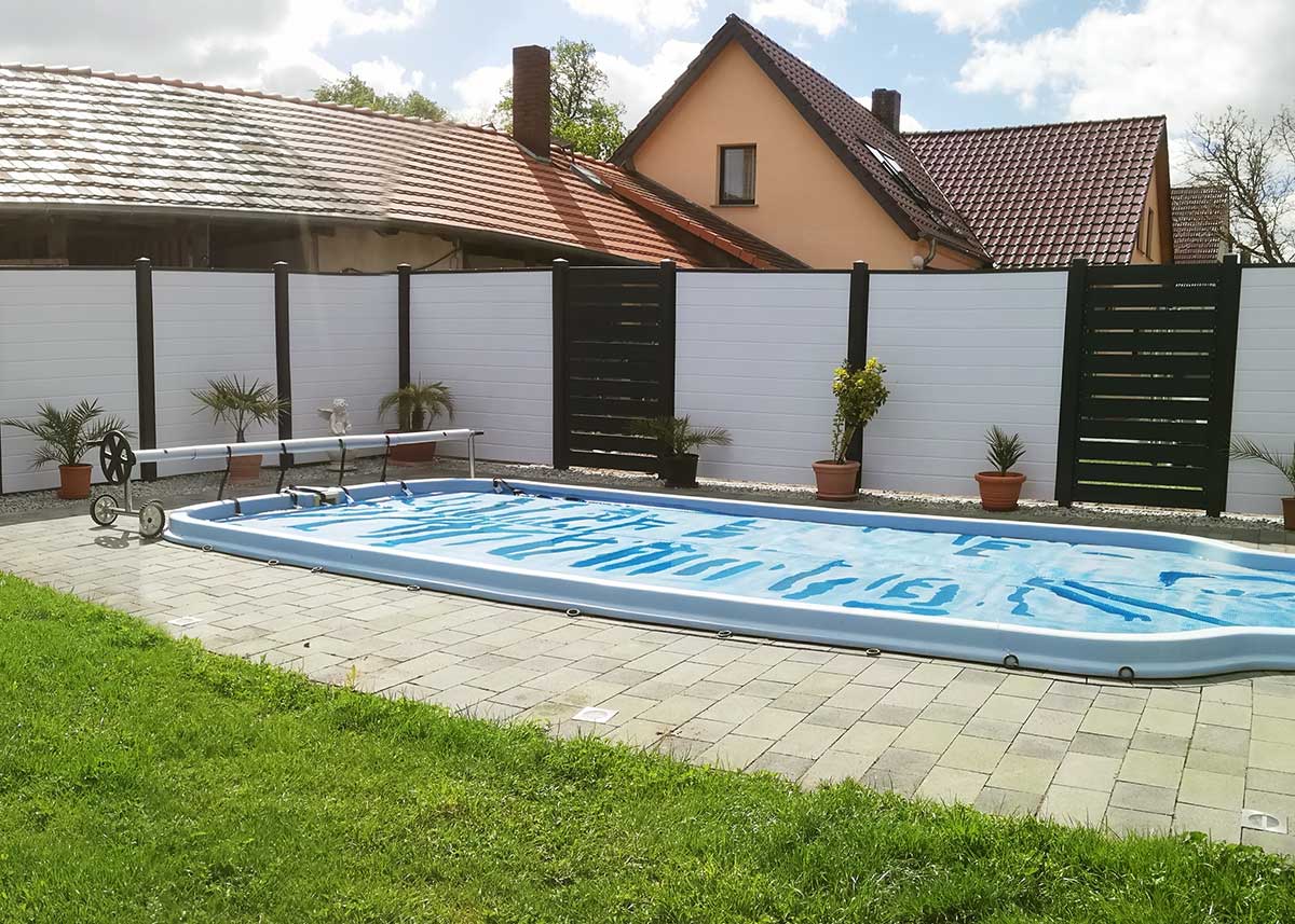 Sichtschutzzaun am Pool in Weiß und Anthrazit mit Zierelementen und Rahmenoptik, blickdichter Kunststoffzaun am Schwimmbecken