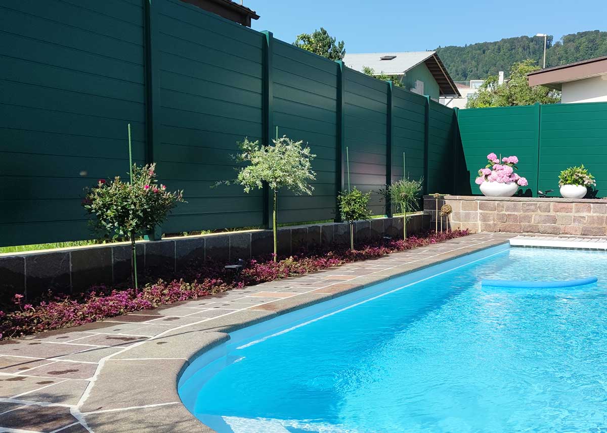Ecoline wetterbeständiger Sichtschutz in Moosgrün als grüne Wand an einem Poolbereich mit Schwimmbecken