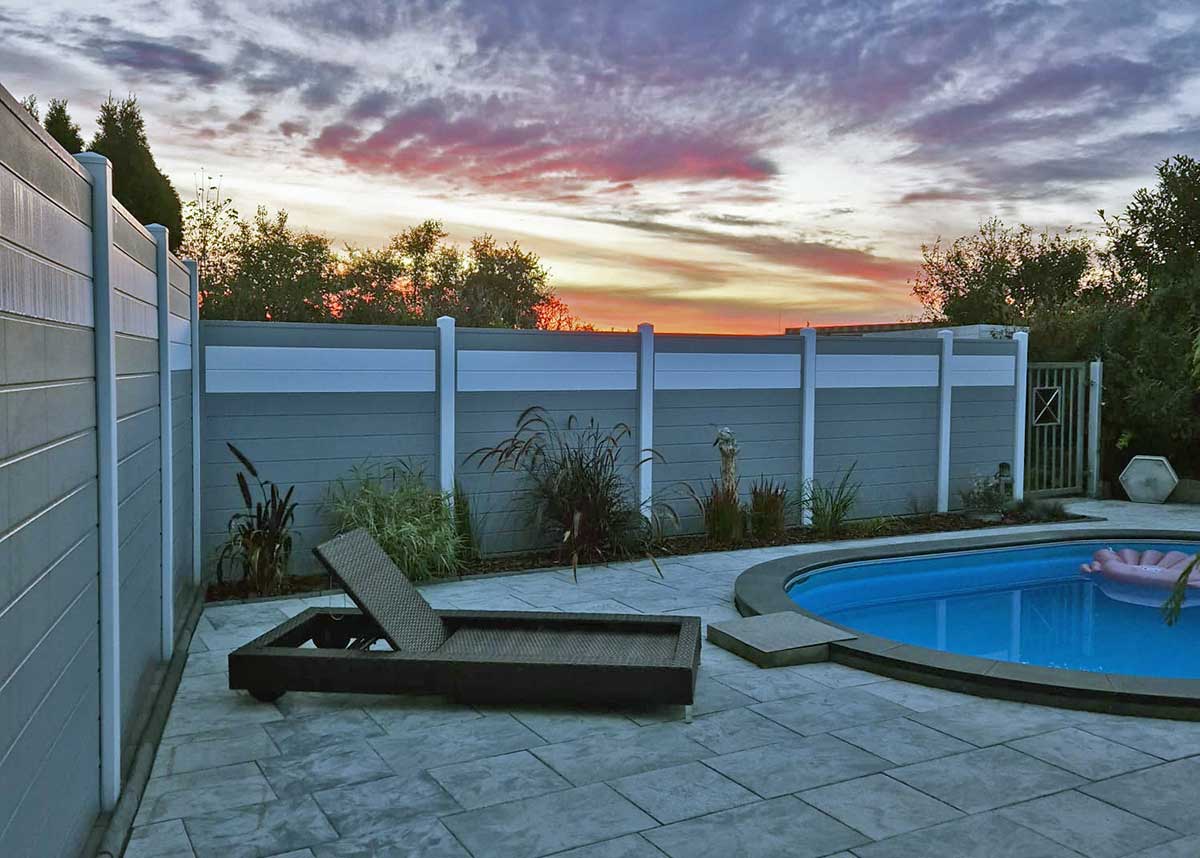 grauer Sichtschutz an einem Pool, bei Abendstimmung