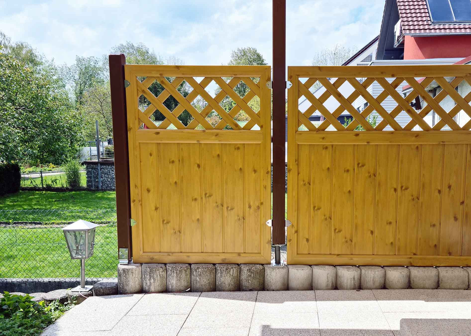 Sichtschutzzaun aus Kunststoff PVC in Astfichte mit Rankgitter auf einer Terrasse