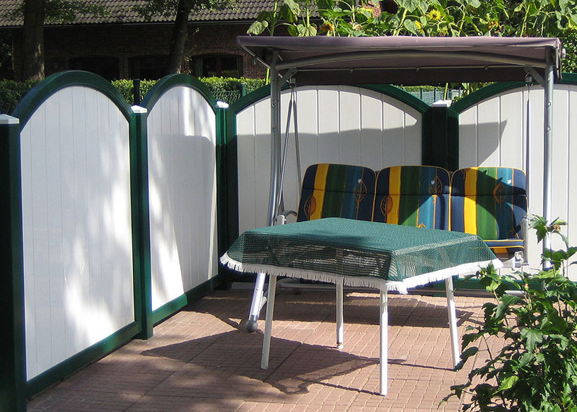 Sichtschutzwand in einer Gartensitzecke in Weiß und einem moosgrünem Rahmen