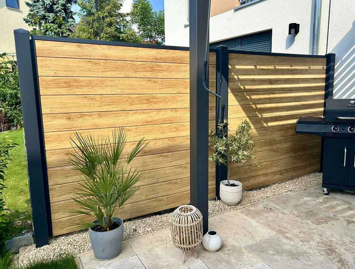 Sichtschutzzaun aus Kunststoff in Holzoptik Desert Oak auf einer Terrasse