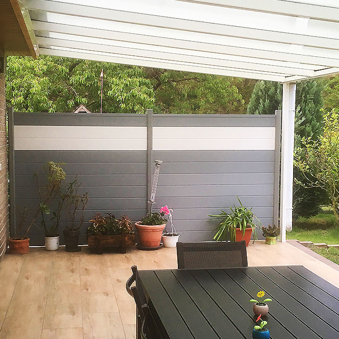 Sichtschutz auf einer Terrasse in Grau mit weißen Akzenten in Form eines Streifens