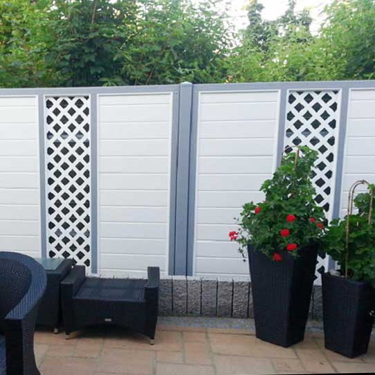 Sichtschutz um eine Terrasse im Garten aus Kunststoff in Weiß mit grauen Akzenten und Rankgitter