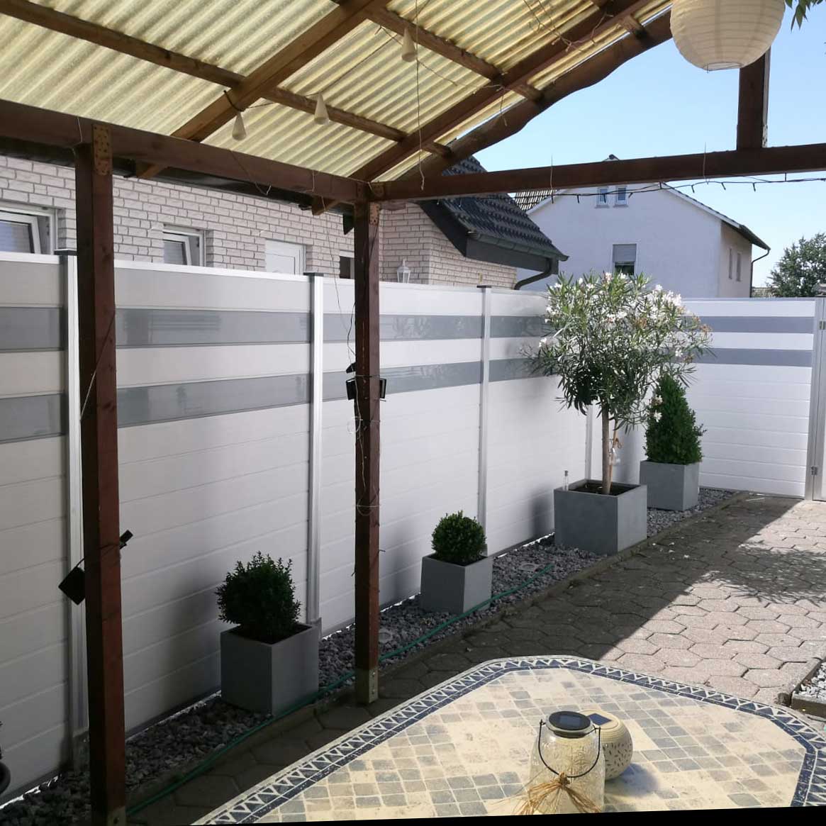 Sichtschutzwand im Hof in Weiß mit grauen Streifen aus Kunststoff