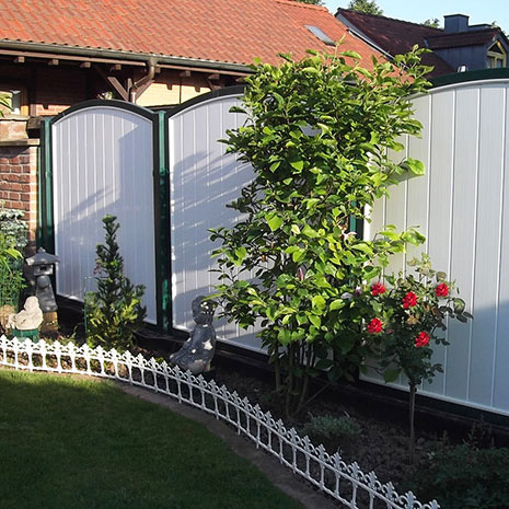 Sichtschutzzaun in Weiss und Moosgrüner Umrahmung aus Kunststoff im Garten mit Oberbogen