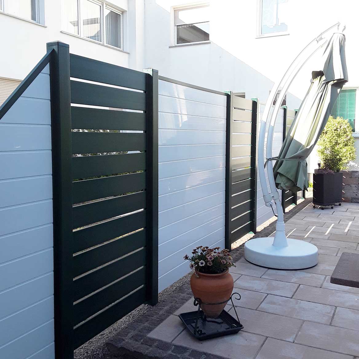 Sichtschutzzaun aus Kunststoff PVC in Anthrazit und Weiß auf einer Terrasse