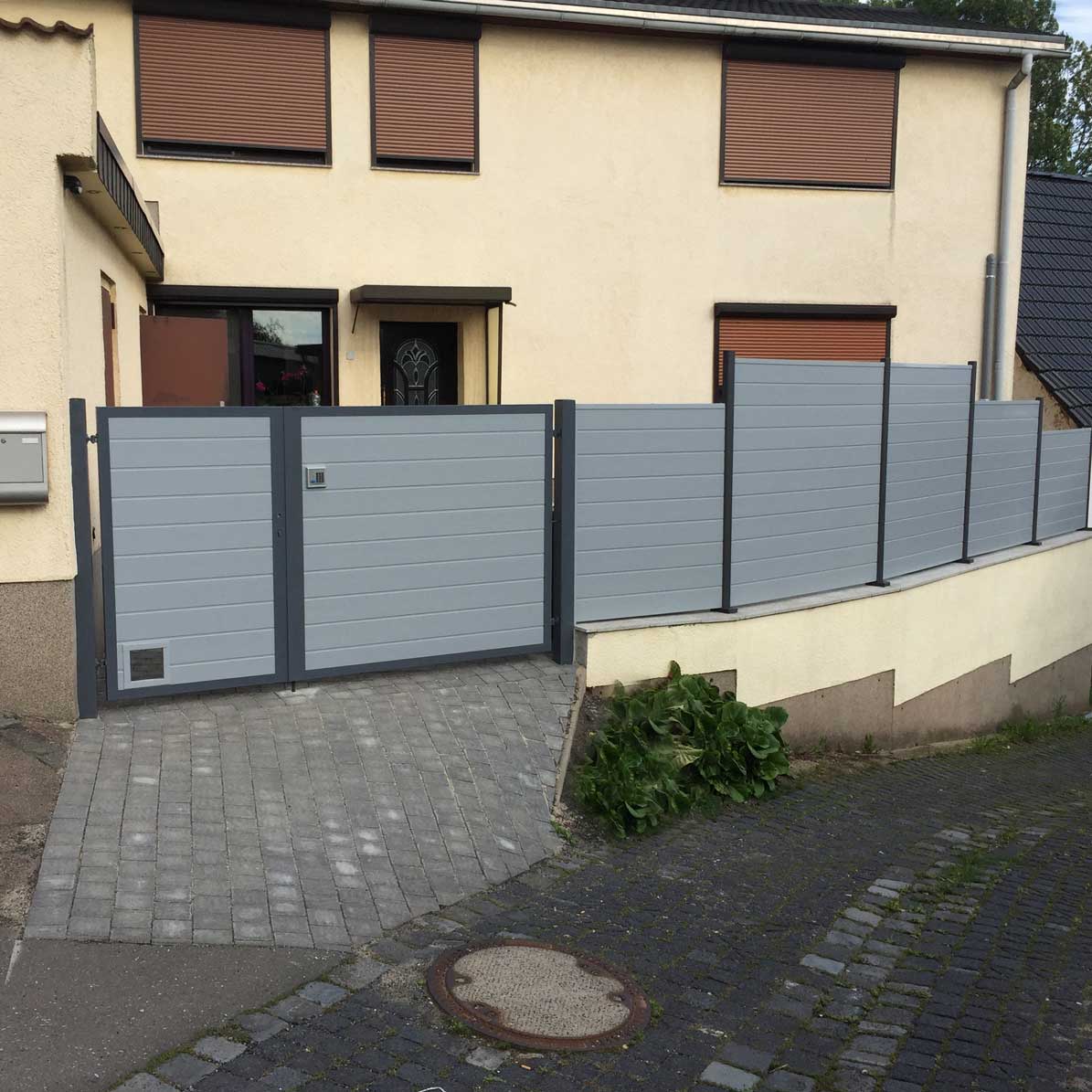 Sichtschutzzaun aus Kunststoff PVC in Grau und Anthrazit als Blickfang auf den Hof mit passendem Tor