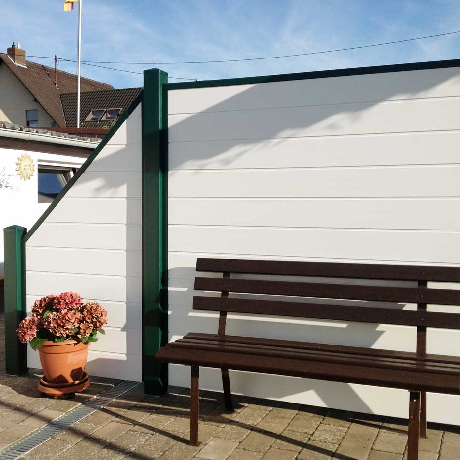 Sichtschutzzaun aus Kunststoff PVC in Weiß mit moosgrünen Umrahmung und Pfosten auf der Terrasse
