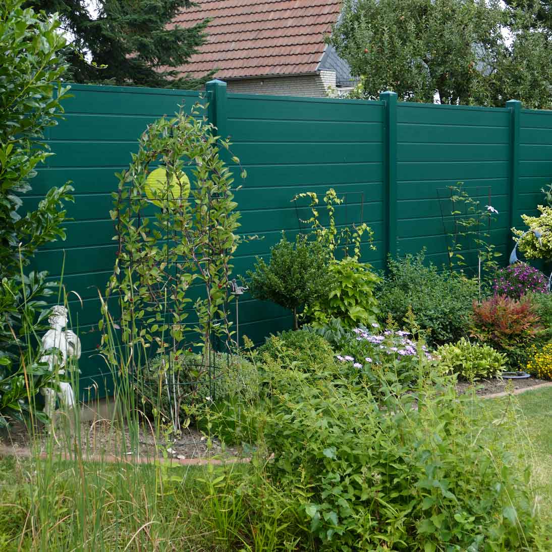 Sichtschutzwand in Grün aus Kunststoff im Garten als grüne Wand wie eine Hecke
