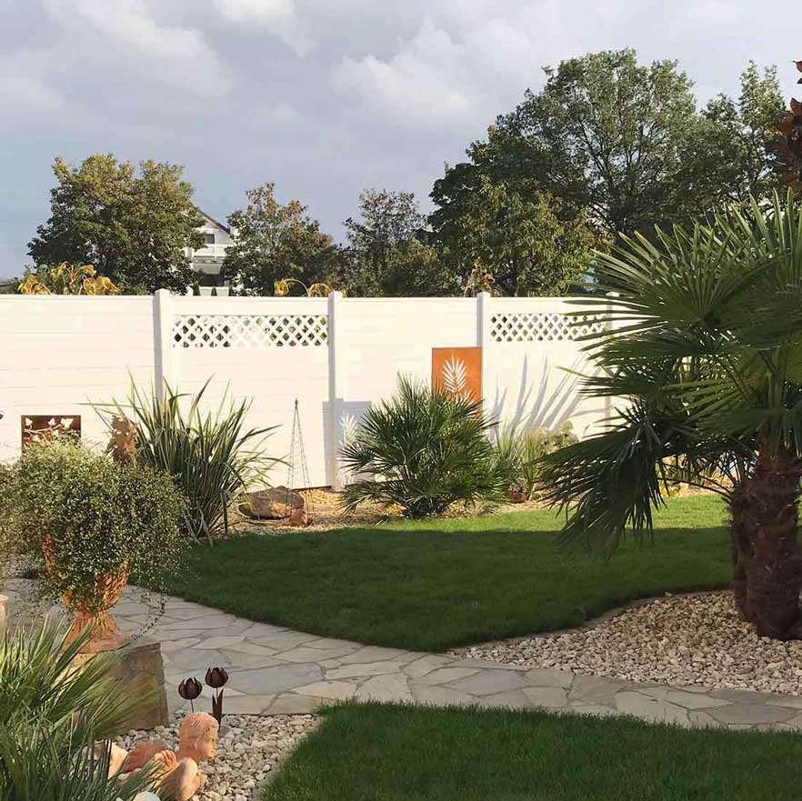 Sichtschutzzaun aus Kunststoff PVC in Weiß im Garten mit Palmen