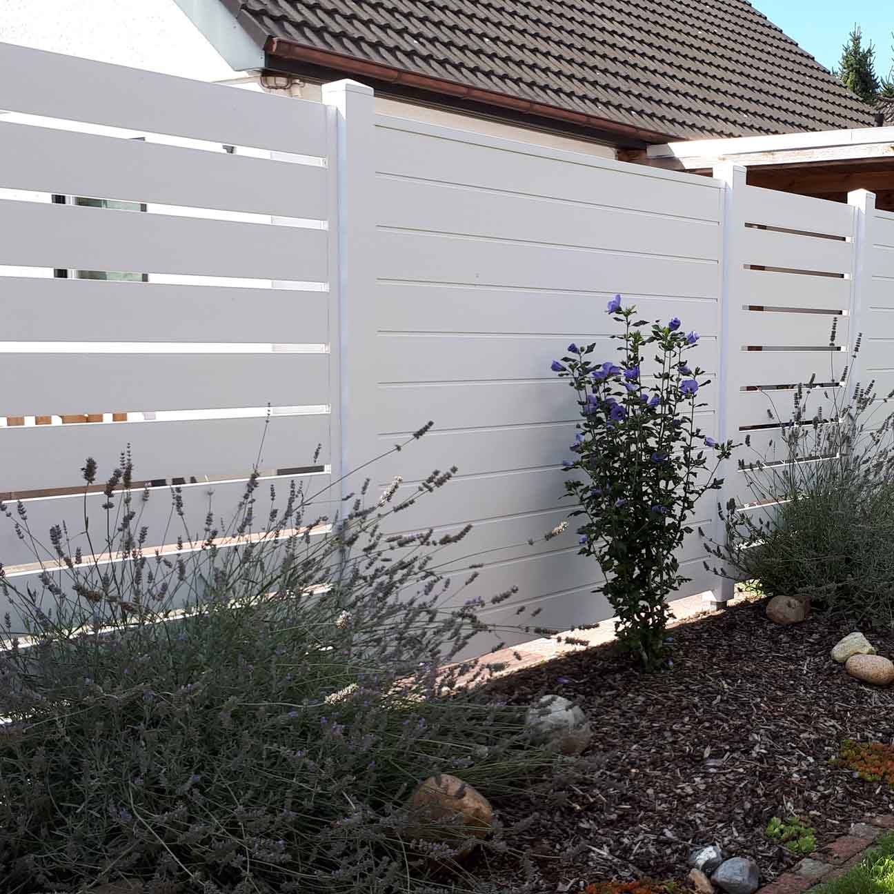 Sichtschutzzaun Spaltsichtschutz in weiß aus Kunststoff im Garten