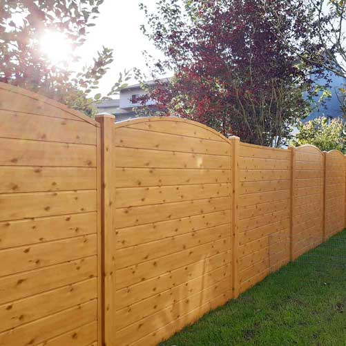 Sichtschutzzaun aus Kunststoff PVC in Holzoptik Astfichte im Garten mit Oberbogen